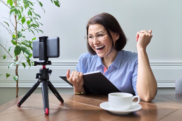 Middleaged woman teacher businesswoman working online using smartphone