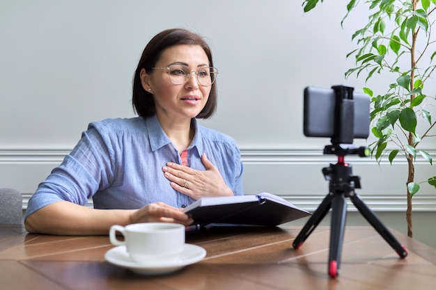 Middleaged woman teacher businesswoman working online using smartphone