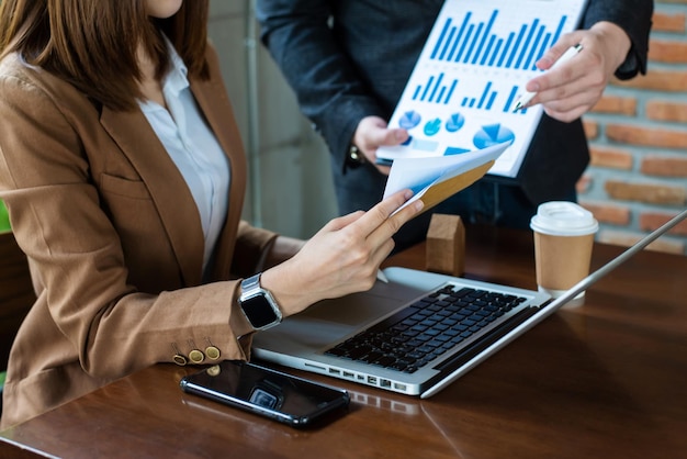 Midsection Of Business team Planning Over Graphs And Wealth On Desk In modern OfficexA