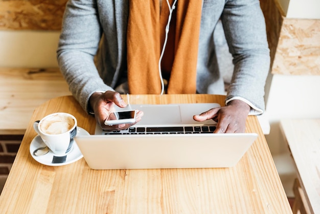 Photo midsection of businessman using laptop while having coffee in cafe