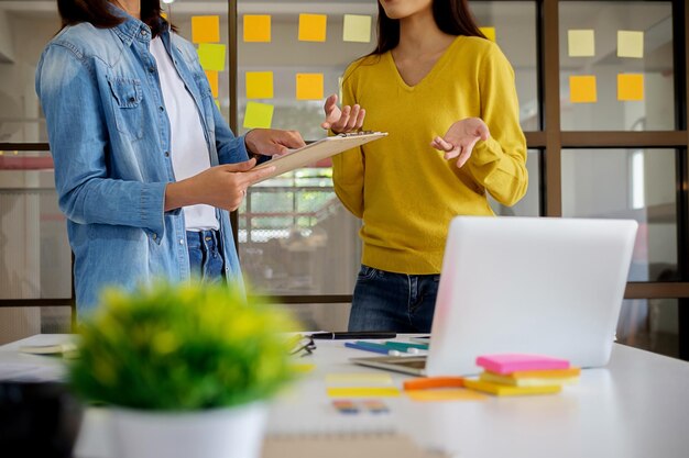 Photo midsection of businesswomen discussing while standing in office