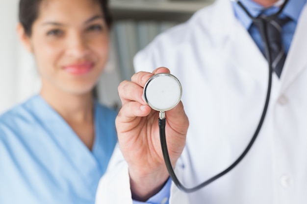 Midsection of doctor holding stethoscope 