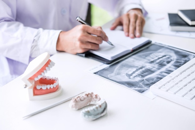 Midsection of doctor working at clinic desk