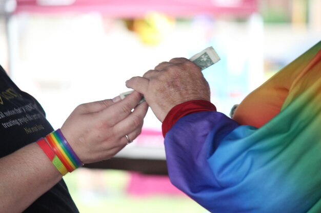 Photo midsection of gay couple holding paper currencies