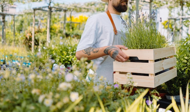 Midsection of male gardener walking and holding box Garden centre shop