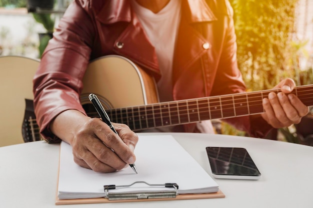 Photo midsection of man holding guitar on table