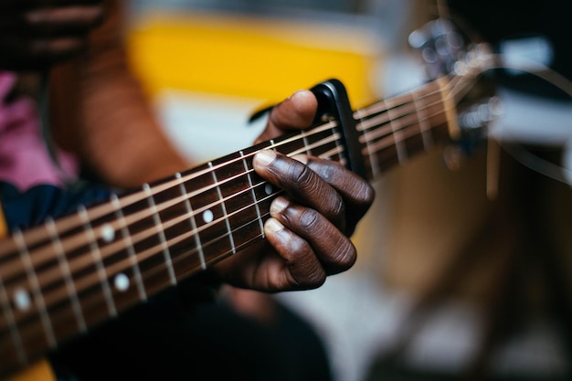 Midsection of man playing guitar