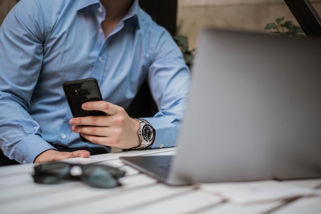 Photo midsection of man using mobile phone in cafe