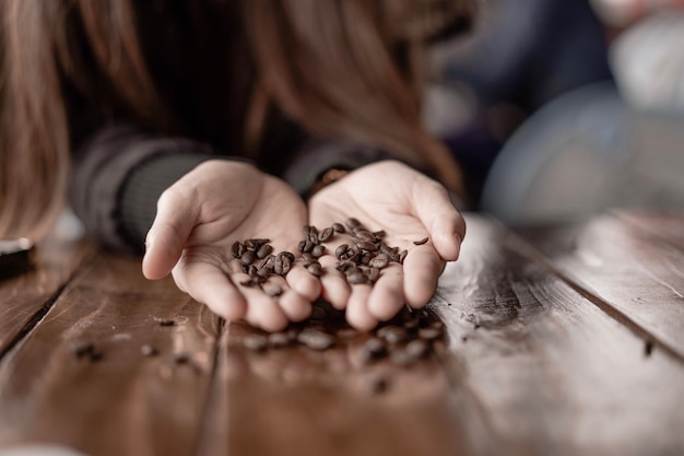 Photo midsection of woman holding roasted coffee beans at table