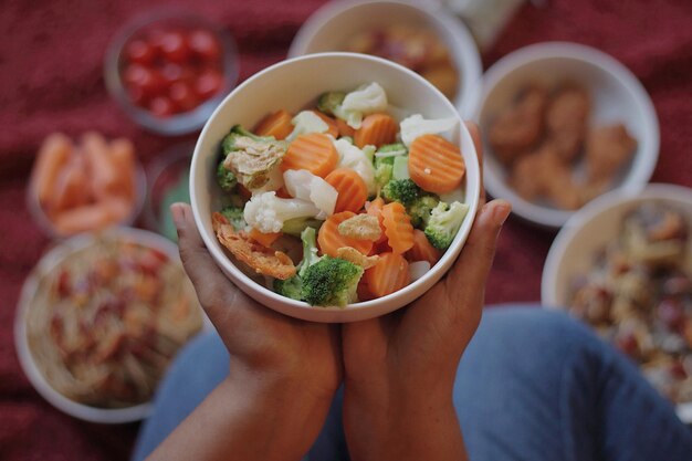 Photo midsection of woman holding salad in bowl