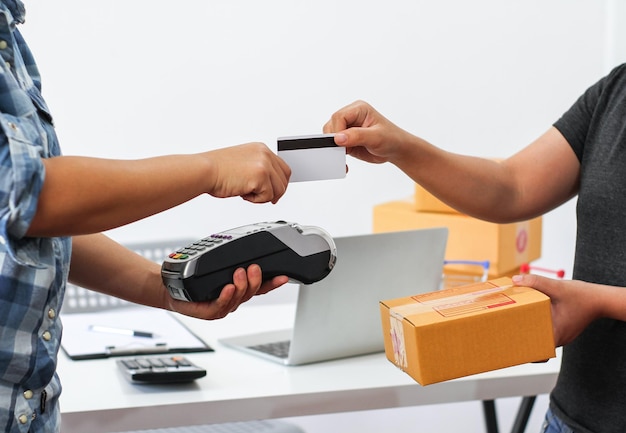 Photo midsection of woman making payment while receiving package on table