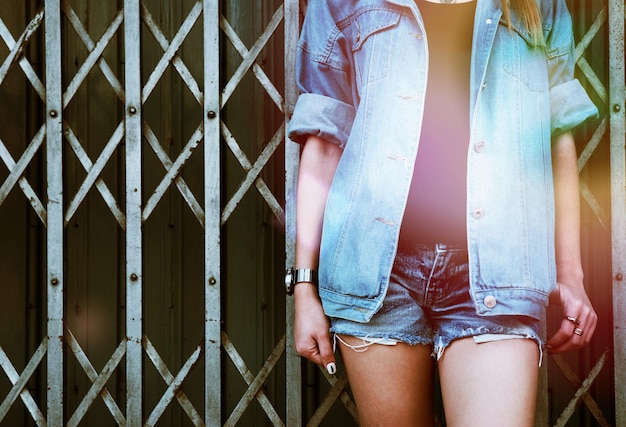 Photo midsection of woman wearing denim jacket standing against gate