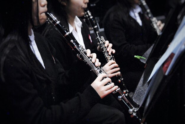 Photo midsection of women playing clarinet graduation ceremony