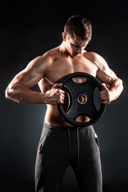 Mighty fitness man showing his gread body with dumbbells