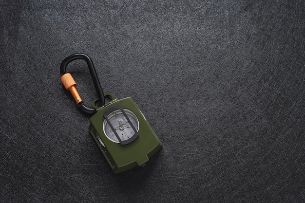 military green compass on textured black background