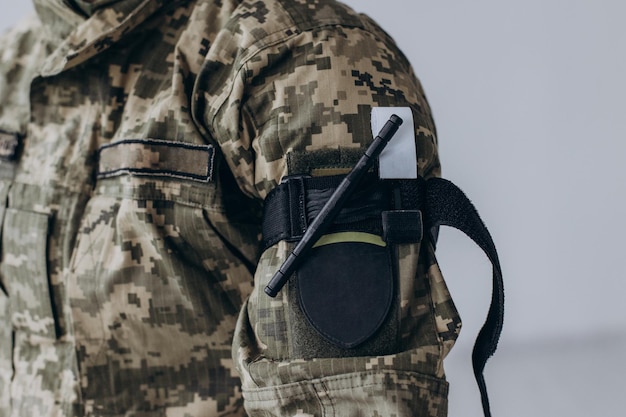 A military man demonstrates a combat medical tourniquet to stop blood during first aid Instructions for combat tactical equipment