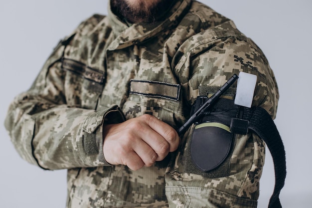 A military man demonstrates a combat medical tourniquet to stop blood during first aid Instructions for combat tactical equipment