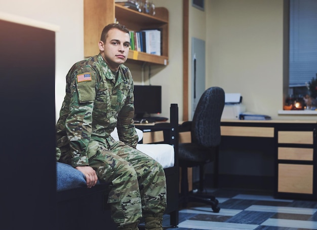 Military service and soldier or man in bedroom at navy for protection war training or USA combat Portrait of veteran in army uniform with courage and government recruitment draft or conscription