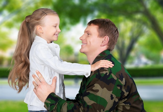 Military soldier man with little girl on background