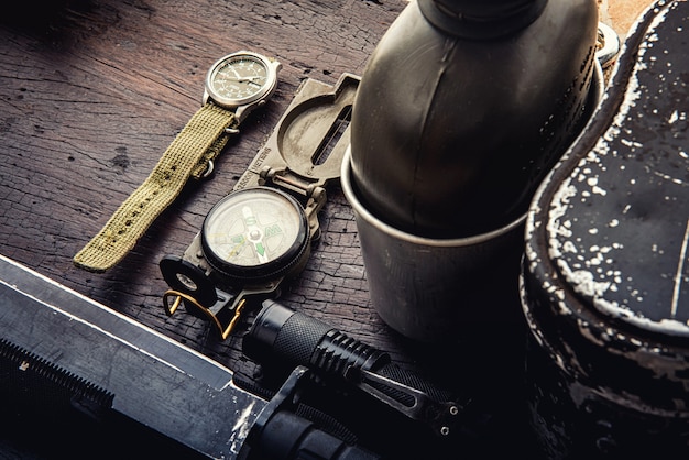 Military tactical equipment for the departure. Assortment of survival hiking gear on wooden background