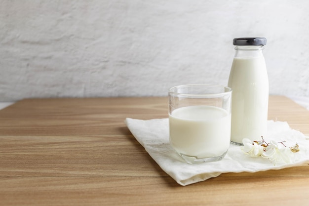 Milk bottle and glass of milk on wooden table