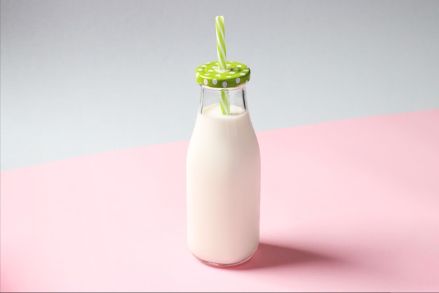 Milk bottle on pink and blue creative background. Horizontal format