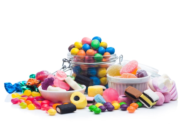 Milk chocolate candies in shell with jelly sugar gums and liquorice allsorts and fruit sherbet candies on white background