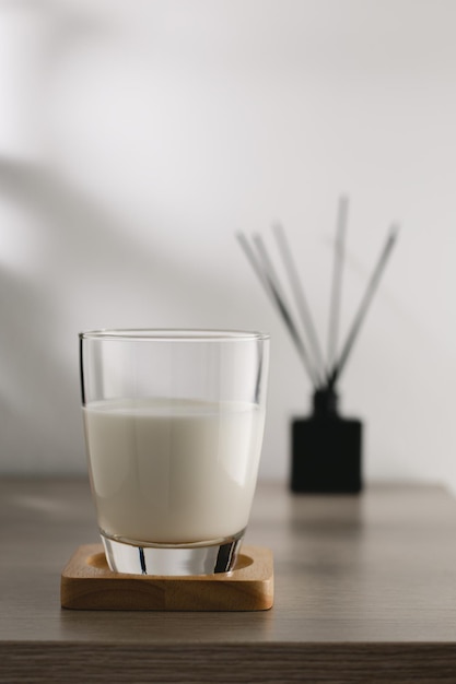 Milk in a clear glass on a wooden table