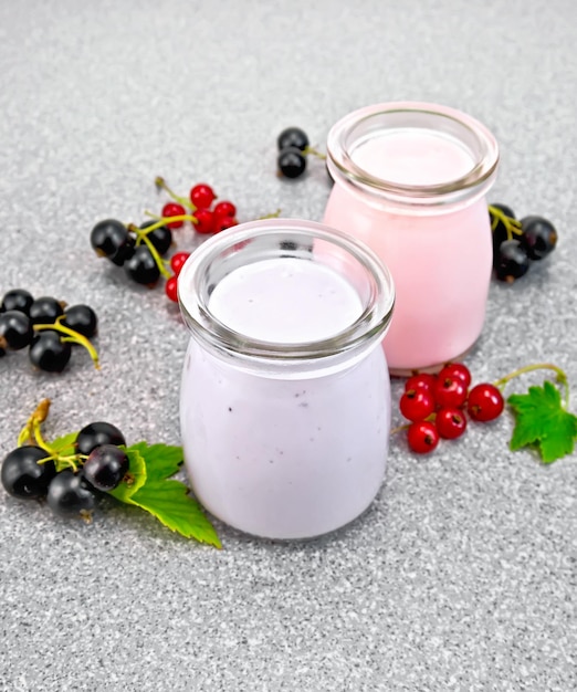 Milk cocktail with black and red currant on granite table