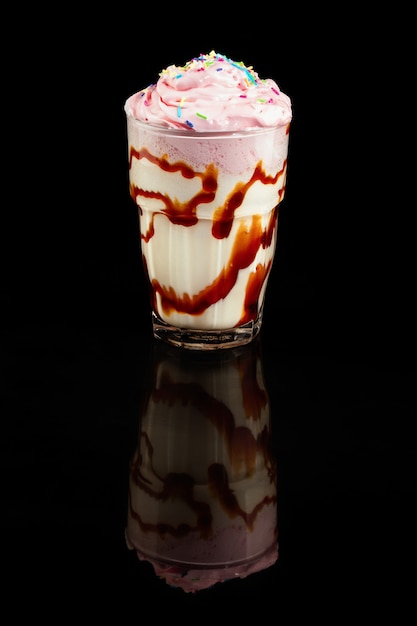 Milk cocktail with ice cream,summer drink in glass, over black background