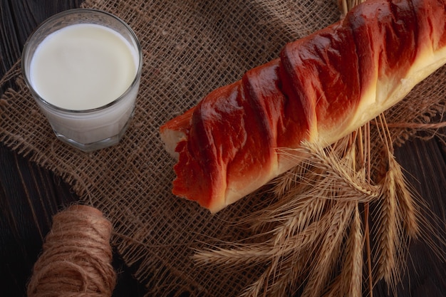 Milk in a glass and white bread on a wooden table