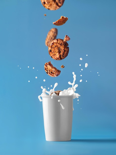 A milk glass with biscuits falling into it