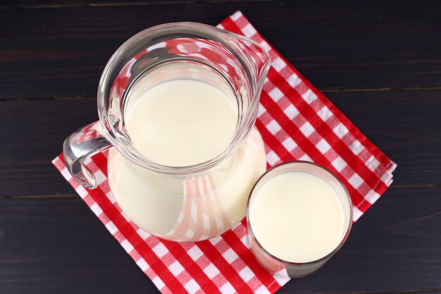 Milk in a jug and a glass on dark boards