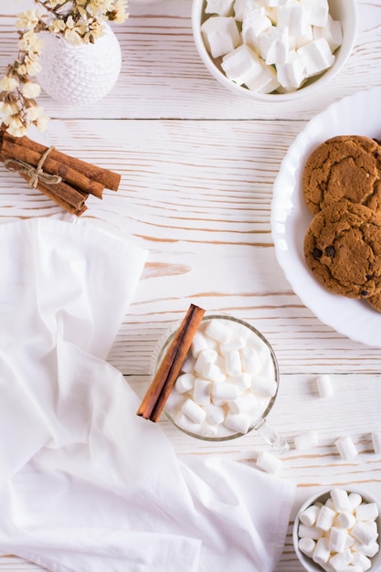 Milk latte with marshmallows in a cup and a plate with homemade cookies Top and vertical view