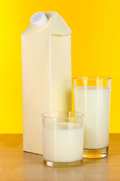 Milk pack on table on yellow background