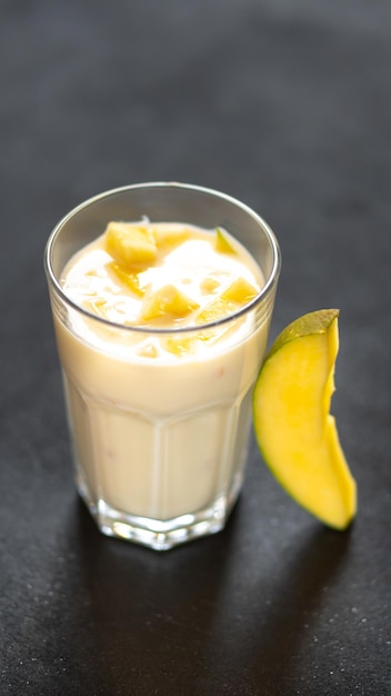 Milk shake on black background with mango pieces