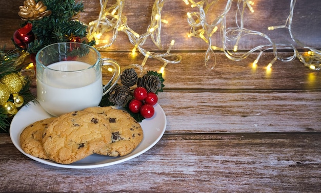 Milk with Christmas cookies for santa claus on a wooden table, selective focus.