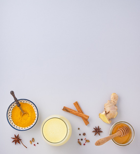 milk with turmeric and honey on gray background