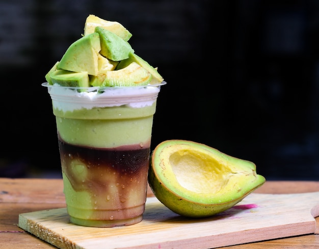 milkshake with avocado pieces, in  plastic cup, delicious and fresh