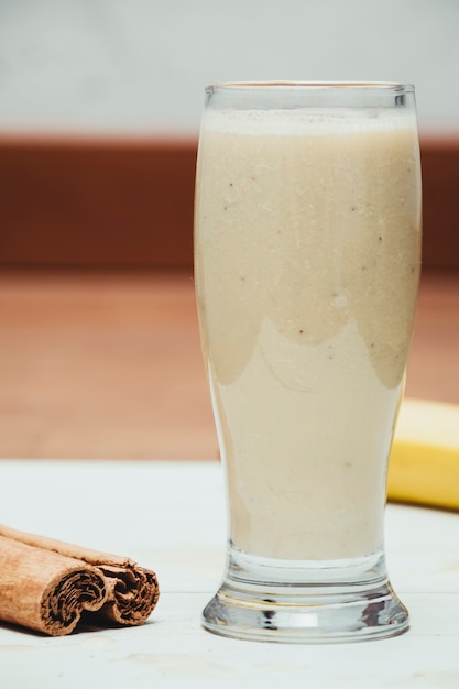 milkshake with banana, oats and cinnamon in a glass, top view, horizontal