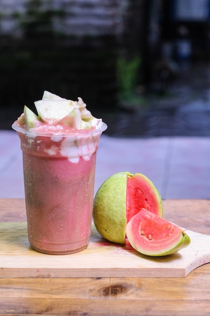 milkshake with guava pieces, in  plastic cup, delicious and fresh.