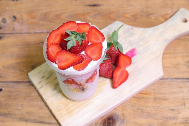 milkshake with strawberry pieces, in  plastic cup, delicious and fresh