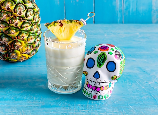 milky coattail garnished with pineapple next bule Mexican skull