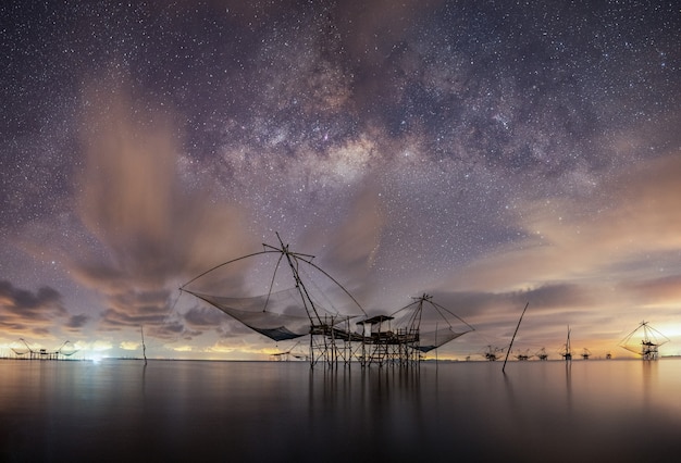 Milky Way with fishing trap net in sea