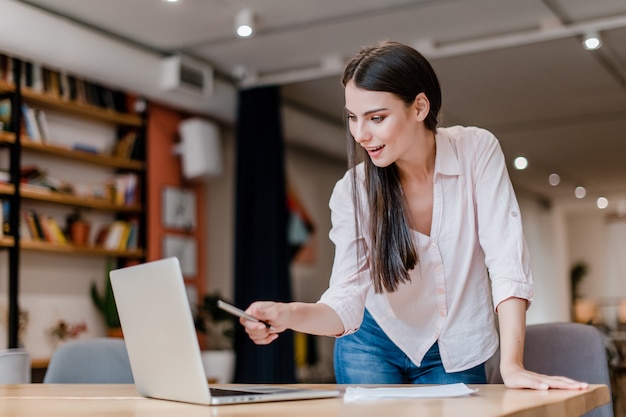 Millenial business woman in her office checking info from her laptop