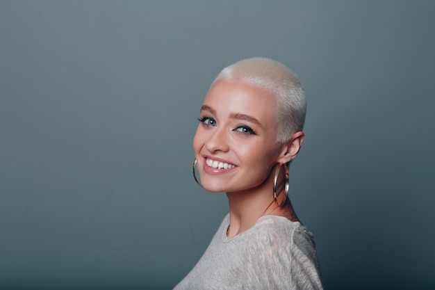 Millenial young european woman with short blonde hair smiling portrait