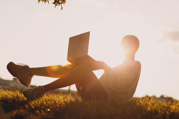 Millenial young woman blonde short hair outdoor smiling portrait with laptop