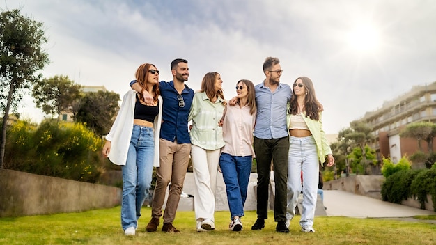 Millenials arm on shoulders walking together in the city park people friendship lifestyle concept