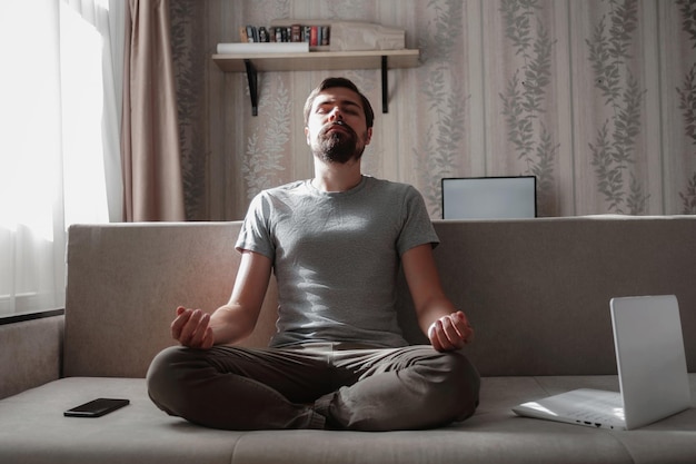 Millennial hipster guy enjoy no stress peace of mind lounge on sofa at home