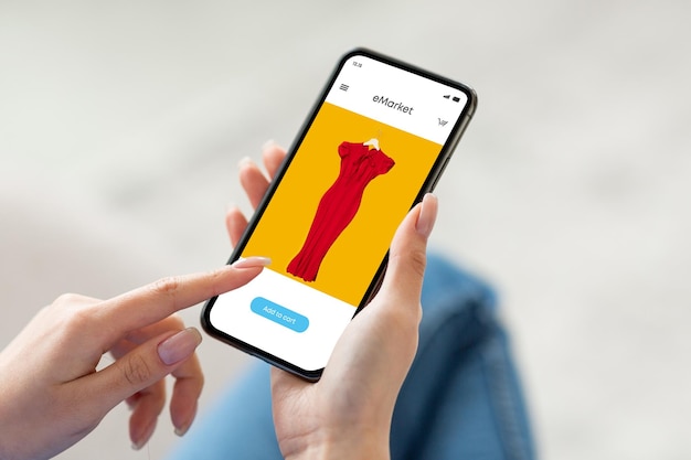 Millennial woman use modern phone with fashion store on screen surfing in internet app enjoy online